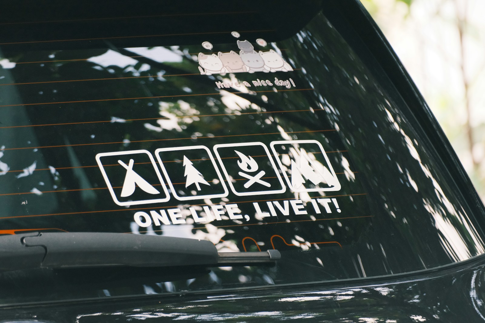 Car window decal with camping and adventure icons.